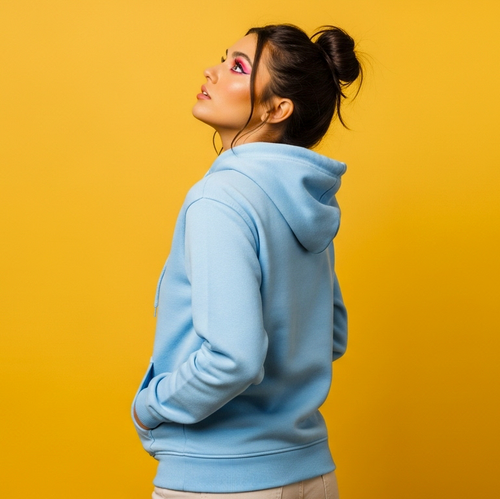 Woman wearing a light blue hoodie against a yellow background